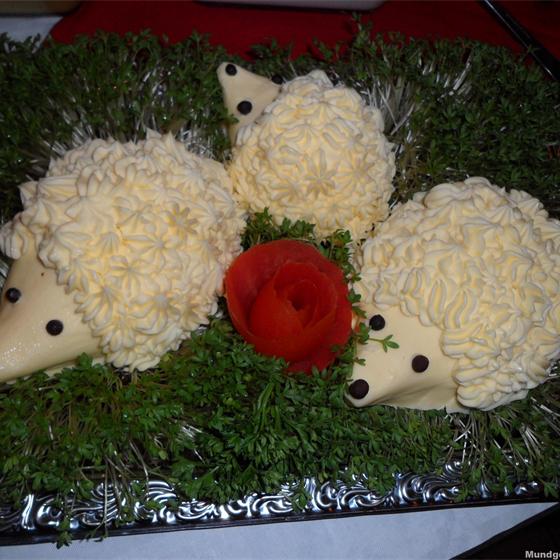 Butterfiguren in Igel-Form mit Tomatenrose auf Salat