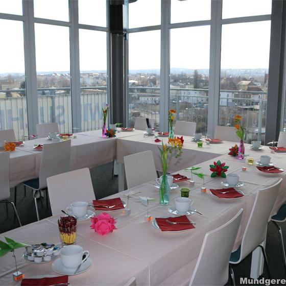 Festlich eingedeckte Tafel in einem hellen Saal